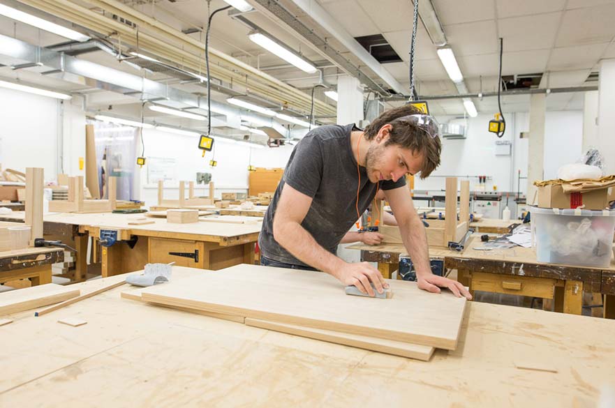An NTU short course student finishing their solid oak table on our furniture making course