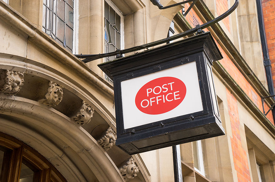 Post office sign hanging from a building