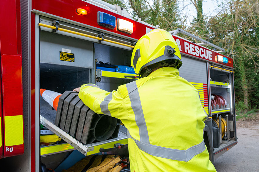 Firefighter getting equipment out of a fire engine