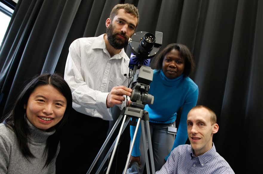 Four students with a camera