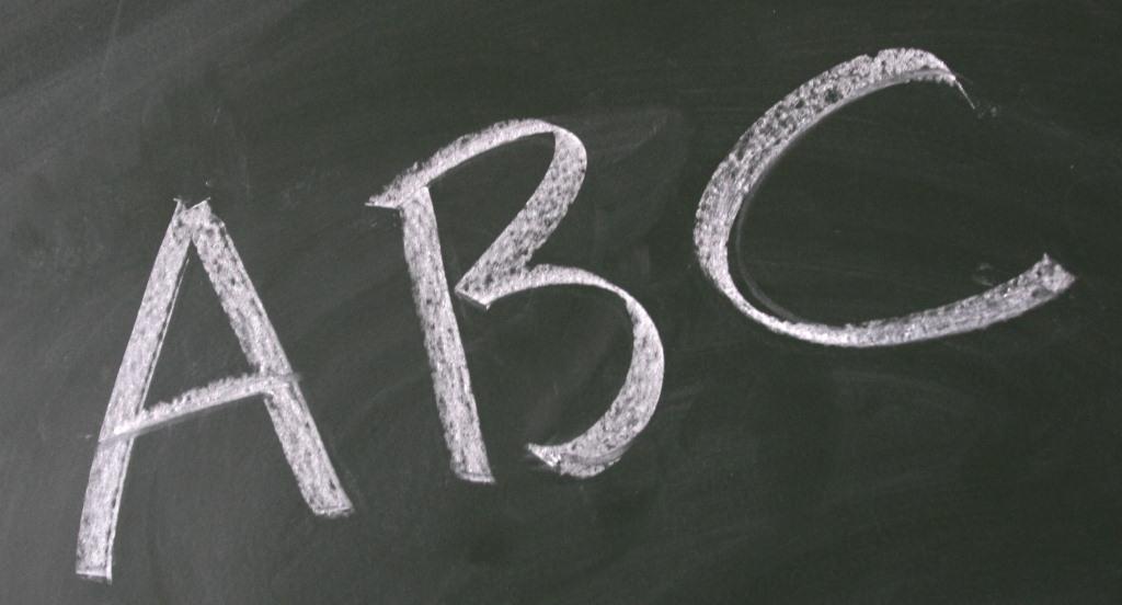 The letters ABC are written out on a black chalkboard. 
