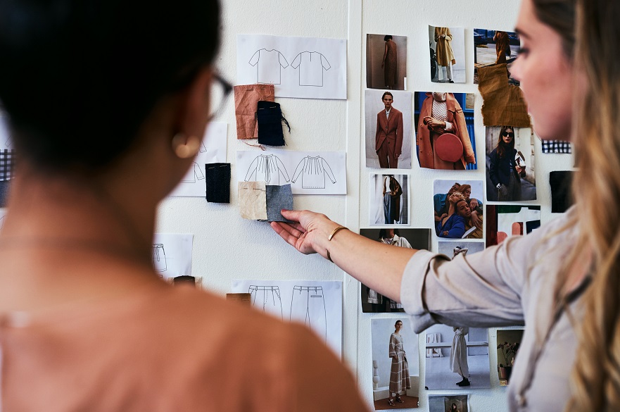 Women looking at clothes samples and drawing