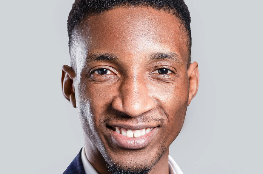 Man smiling looking into camera with plain white background