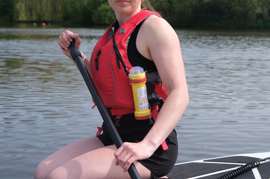 Someone sitting on a paddleboard.