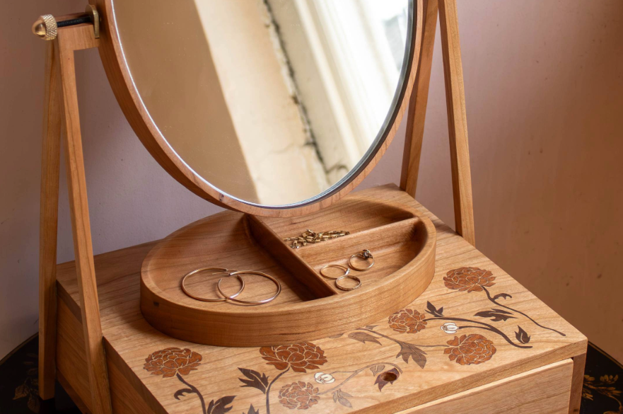 A vanity tabletop with mirror and compartments for jewellery.
