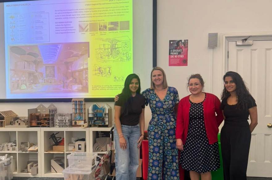 Two postgraduate students and two members of the Hope Church project posed for a photo in an Architecture teaching studio.