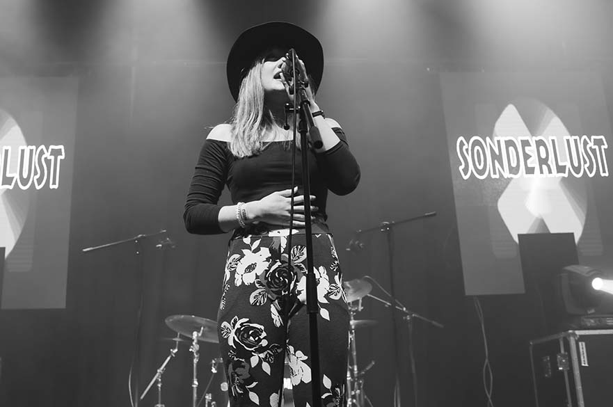 A female singer stood on stage in front of a microphone.