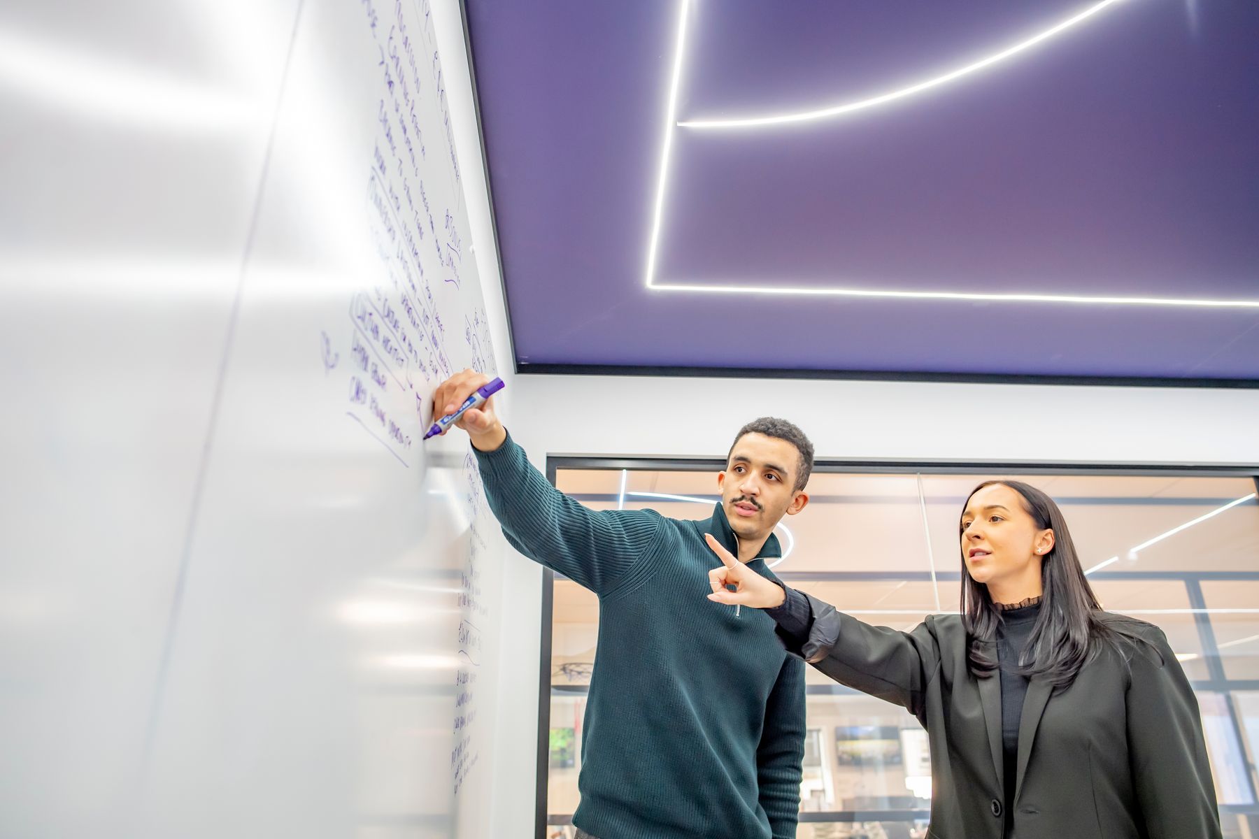 Employees pointing at whiteboard