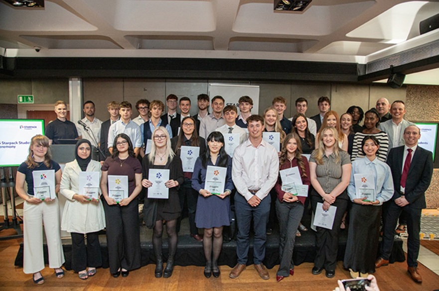 A group of students holding up prize certificates.