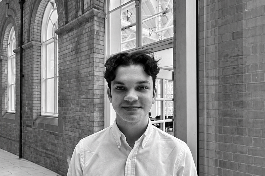 A black and white photo of a person facing the camera to have their picture taken.