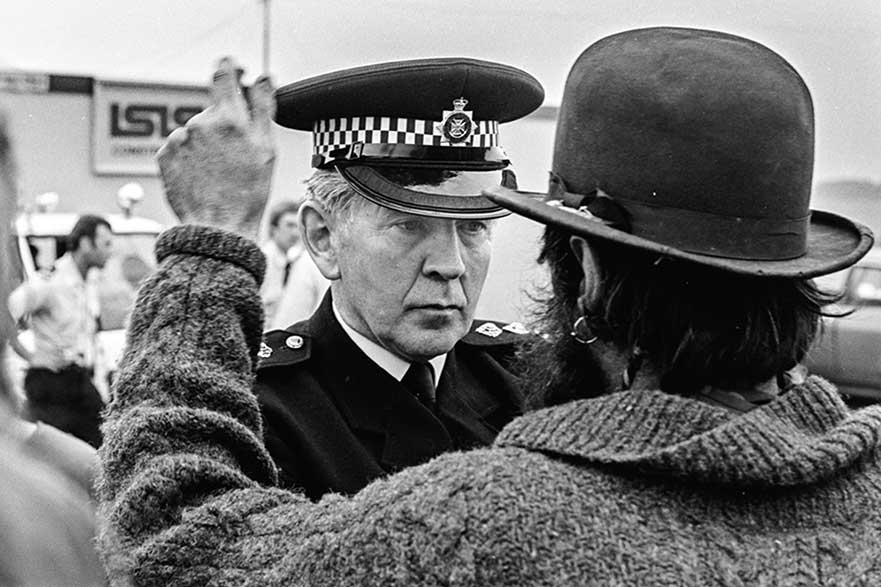 A protestor shouting in the face of a policeman