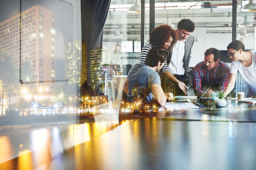 People around a table with a city in the background