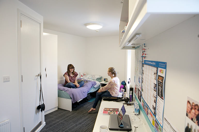 two students chatting in an NTU residence bedroom