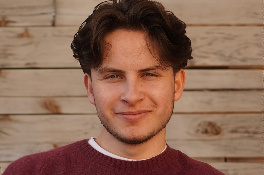 A person smiling, posing for a photograph.