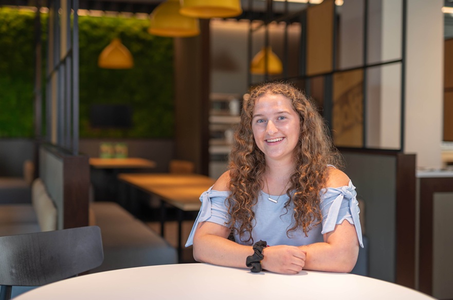 A person sat at a table, smiling for the camera.