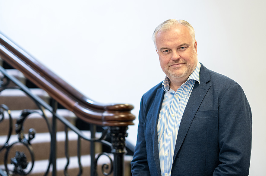 Philip Bell-Brown, a member of the Board of Governors, wearing formal attire and posing for a professional portrait