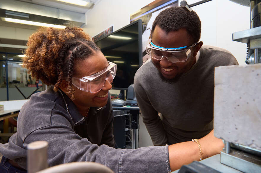Two students using concrete testing faciliites