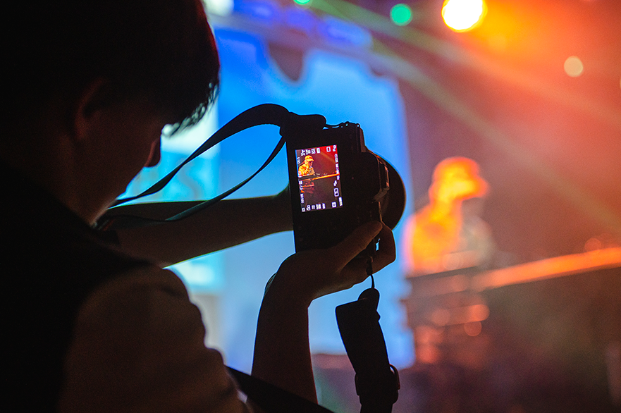 Content Creation student taking picture at a gig