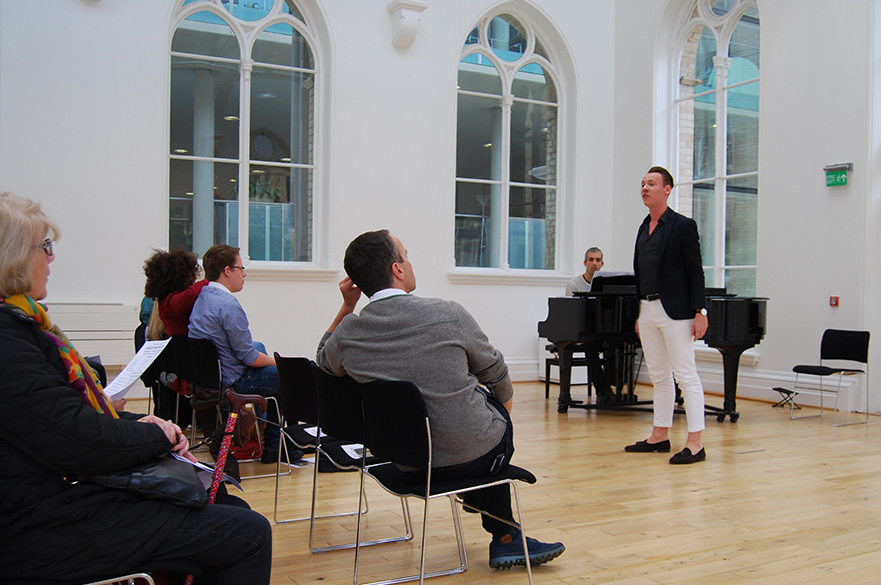 A male singer performing in front of an audience.