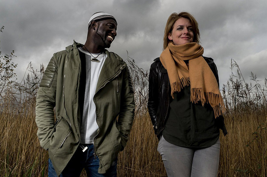 Catrin Finch and Seckou Keita stood together in a field.