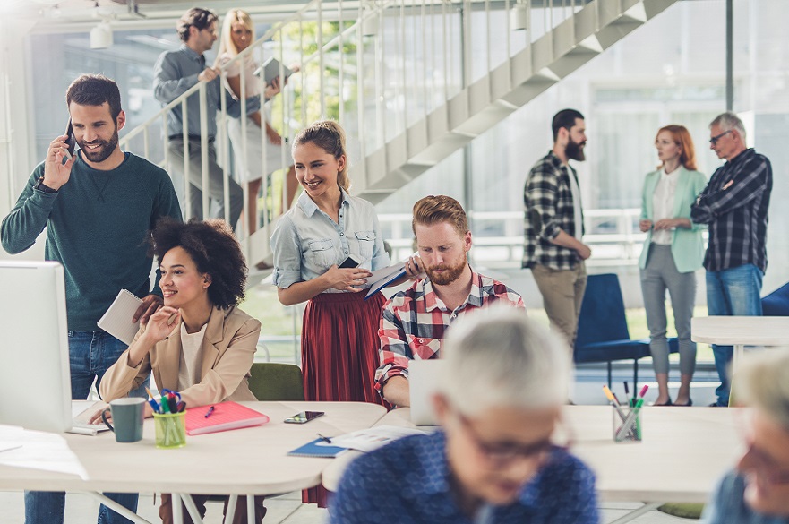 Employees are casually dressed, walking, chatting and working in an office 