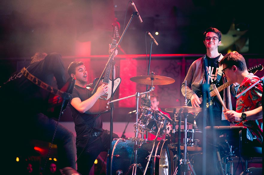 A group of four male students playing in a band.