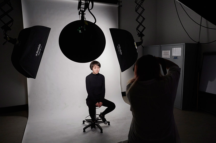 Someone being photographed in a photography studio.