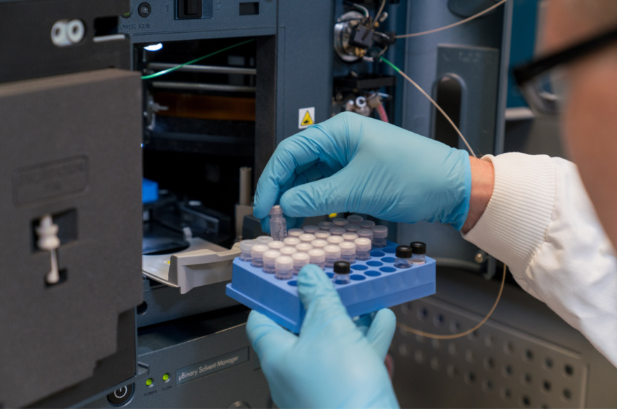 A tray of test tubes being check and placed into a machine..