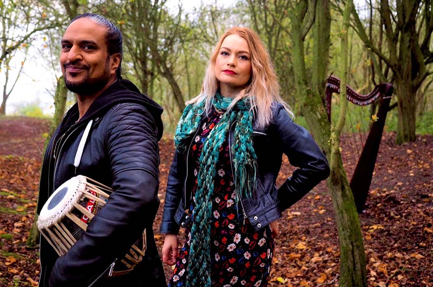 Mendi Singh stood with a tabla and Eleanor Turner surrounded by trees.