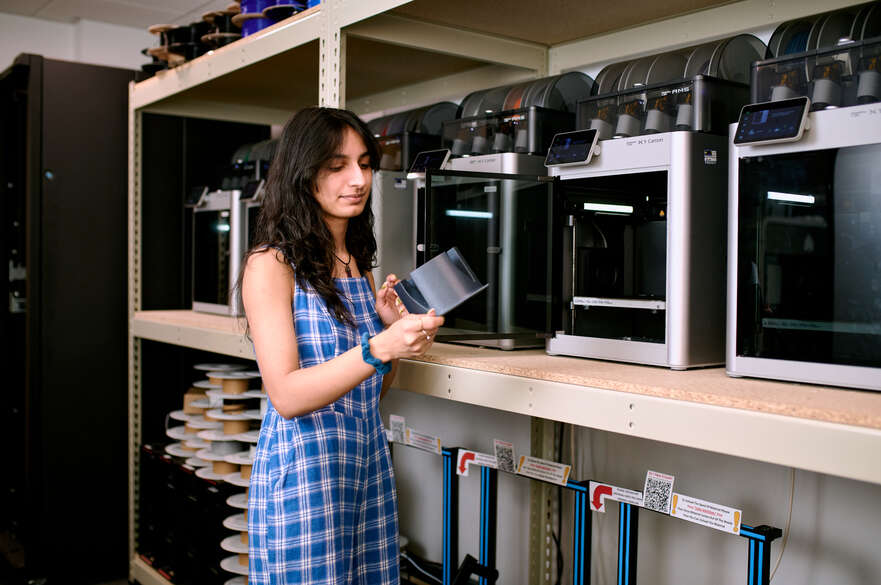 Student stood looking at 3D printed model