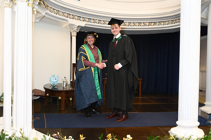 Philip James Lynch graduating and shaking hands with an academic