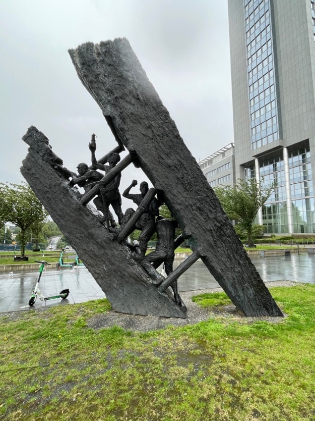 A photo showing a metal sculpture depicting miners