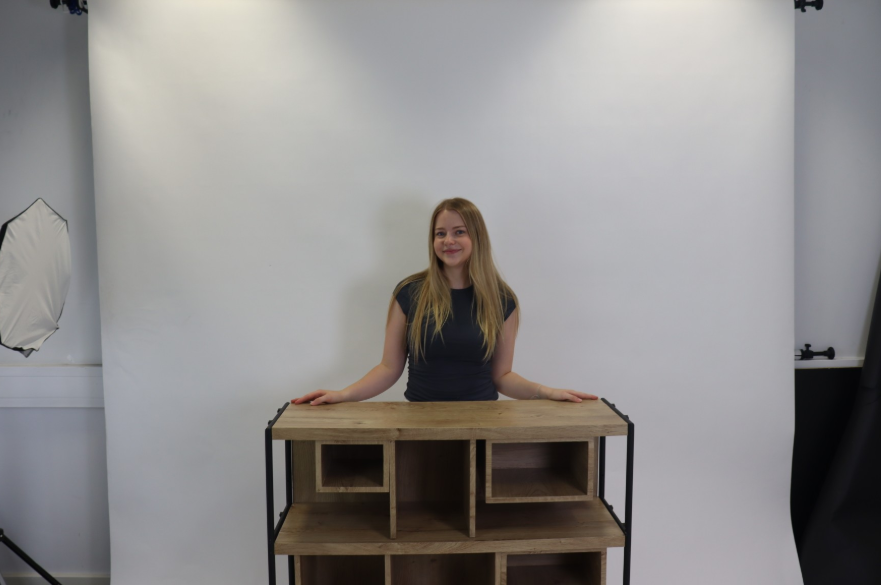 An NTU product design student poses with a piece of furniture she has designed and built. She is facing the camera.