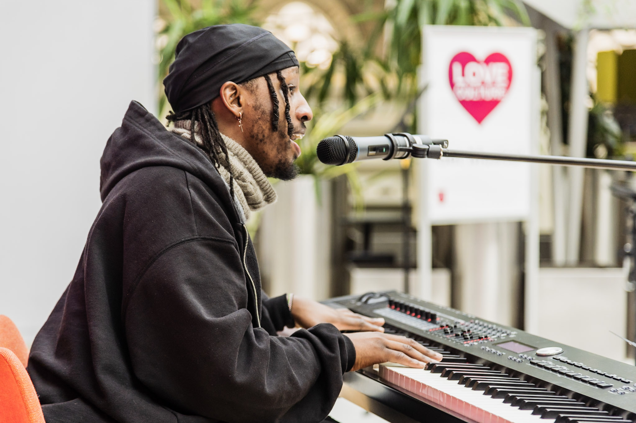 Student playing a keyboard and singing into a microphone