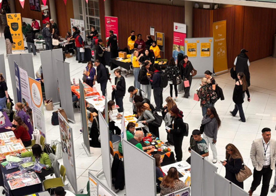 A large number of students explore a number of stands at the Volunteer Fair
