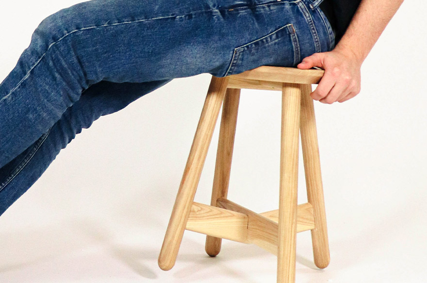Person sitting on a wooden stool