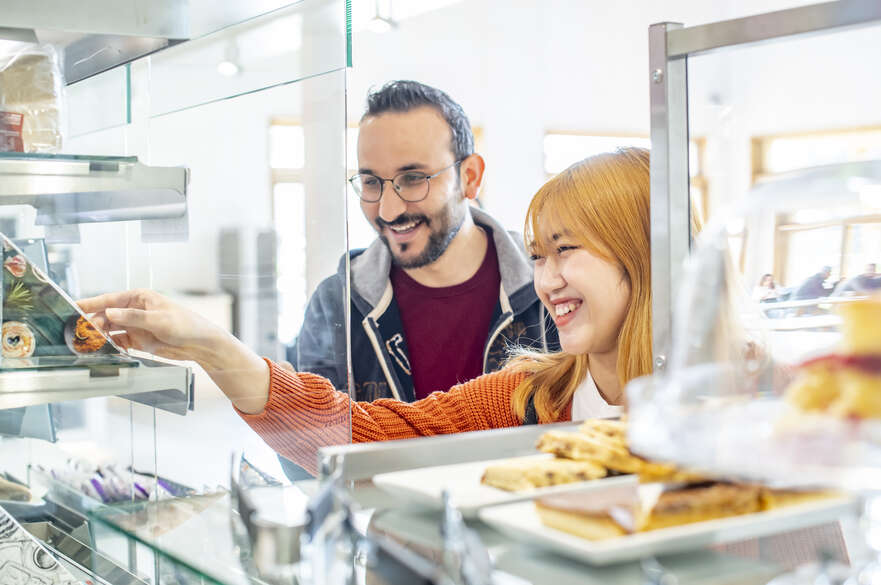 Two students choosing a sandwich from a chiller cabinet