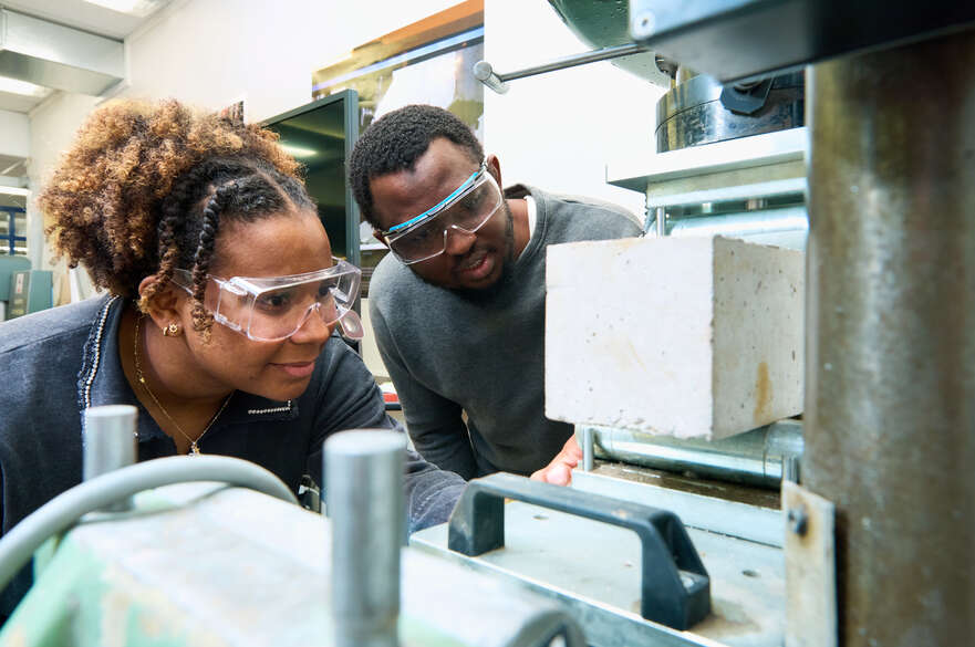 Two students inspecting concrete after testing