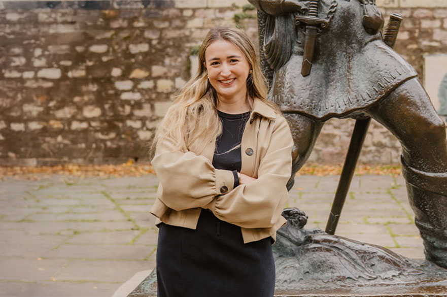 Eve smiling and posing next to the Robin Hood statue in Nottingham.