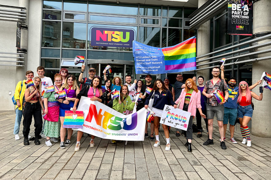 A group of colleagues outside NTSU holding banners and flags for the Nottingham Pride March