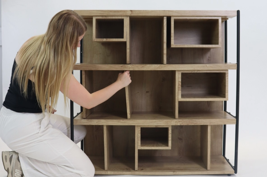 A product design student finishing assembly of a piece of storage furniture she has created.