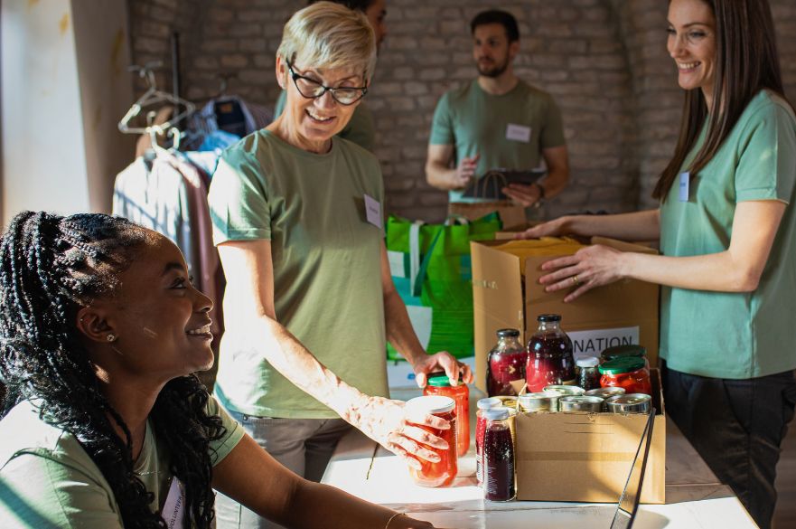 Group of volunteers with working in community charity donation centre