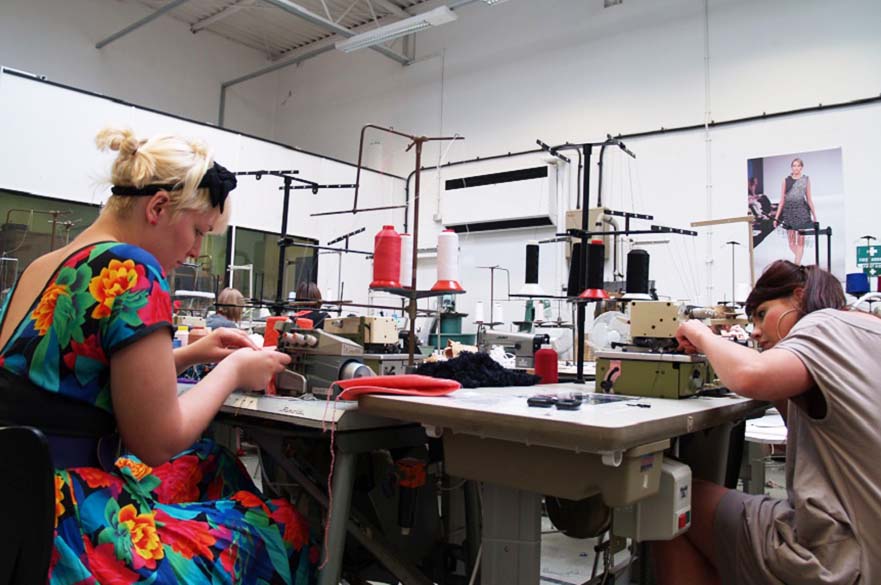 A workshop space with two students working on sewing projects.