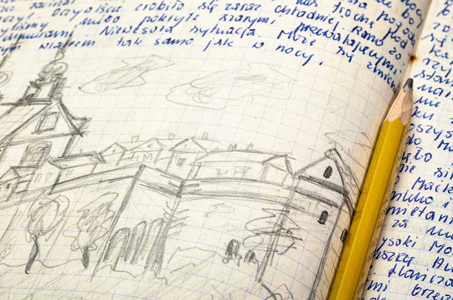 A notebook with a pencil sketch of some buildings and neat, blue handwriting