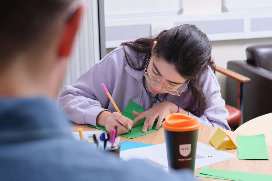 A person writing at a table.