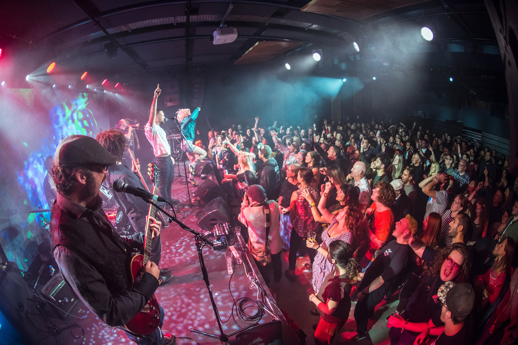 A band playing on a stage in front of a large crowd at Metronome.