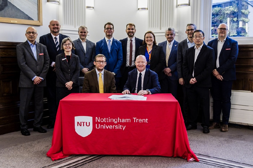 A group of people at the signing of a signed a three-year Strategic Partnership Agreement