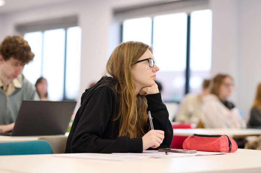 student holding a pen in a seminar
