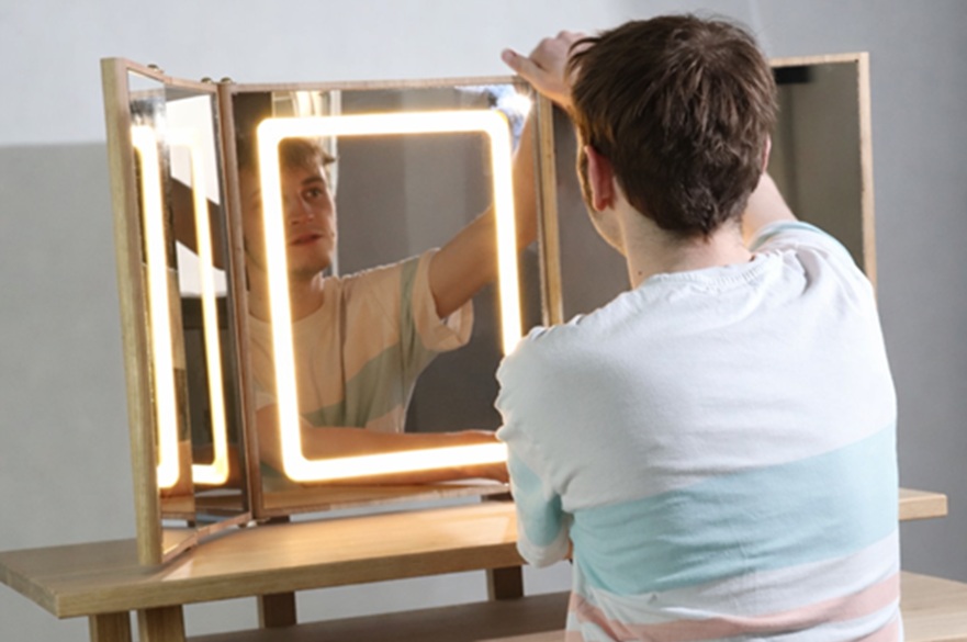 A person is putting the finishing touches to a dressing table they have made.