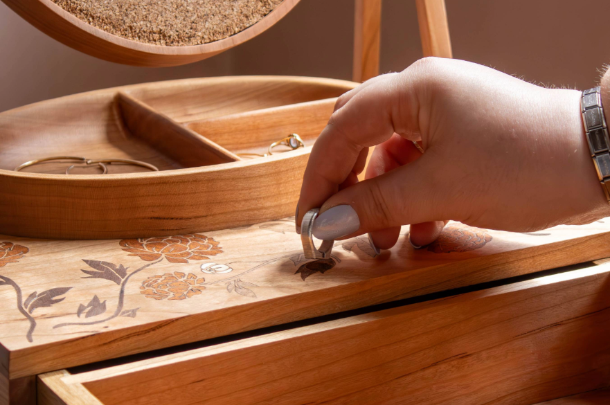Close-up of a hand locking a drawer with a key.
